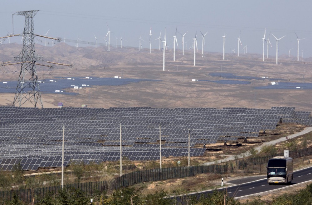Let meA bus moves past solar and wind farms in northwestern China. Beijing is using the kind of investments and regulations President Trump opposes to become the world leader in this fast-growing source of new jobs. CREDIT: AP Photo/Ng Han Guan.