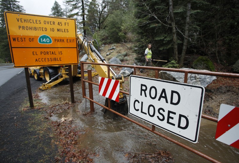 Road crew member Jeremy Brown helps clean up state route 140 near the Merced River in a closed off Yosemite National Park, Calif., Sunday, Jan. 7, 2016. CREDIT: Gary Kazanjian/AP Photos