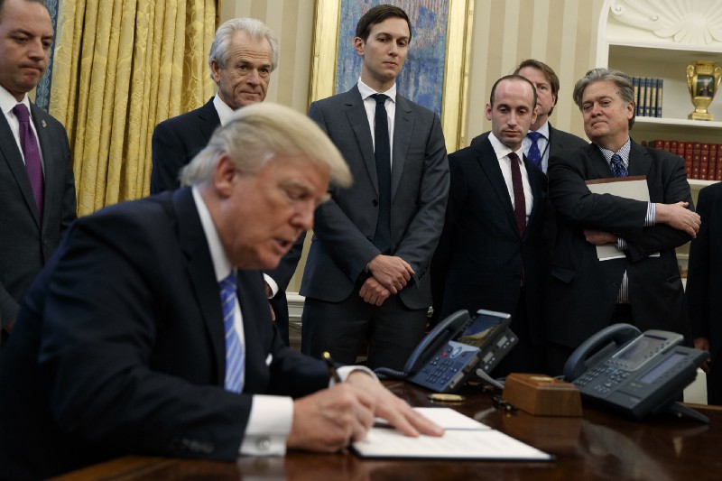 President Trump signing presidential memoranda on Monday. CREDIT: AP Photo/Evan Vucci