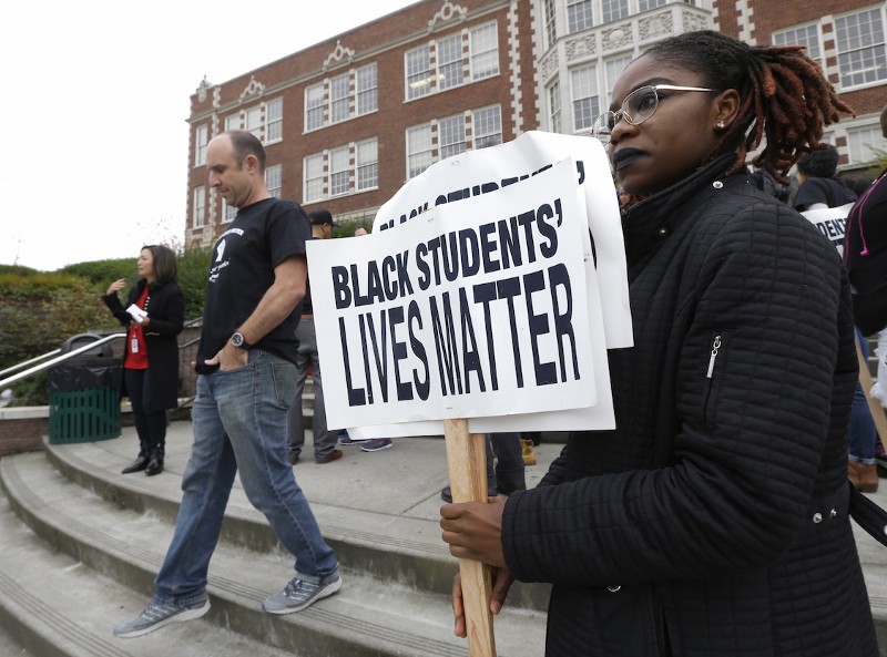 Felecia Bazie, 18, a senior and president of Associated Student Government at Garfield High School in Seattle, holds signs following a “Black Lives Matter” rally Wednesday, Oct. 19, 2016. CREDIT: AP/Ted S. Warren