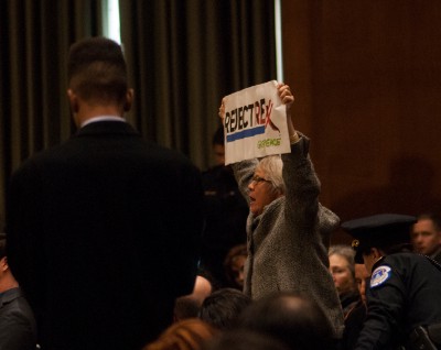 LEFT: Joan Flynn is escorted out of Rex Tillerson’s confirmation hearing by Capitol Police. CREDIT: Pat Ryan/Greenpeace CENTER: Activists gather outside of the Capitol to protest Rex Tillerson’s nomination. CREDIT: Robert Meyers/Greenpeace RIGHT: Greenpeace activist Beth Henry of Charlotte, N.C., protests inside the confirmation hearing. CREDIT: Pat Ryan/Greenpeace