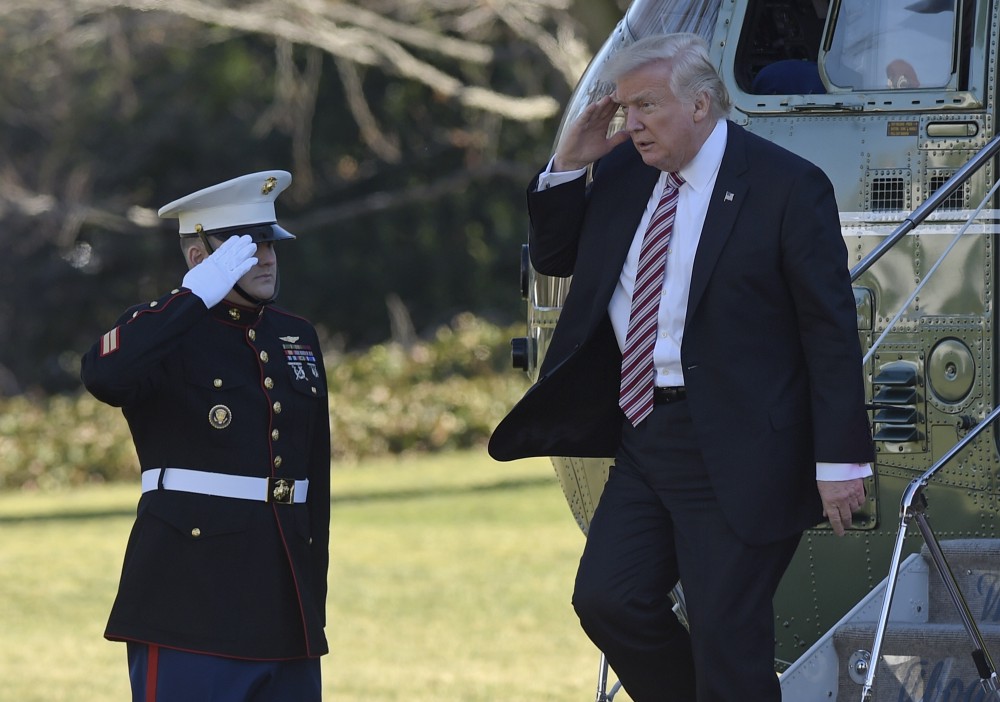 President Donald Trump salutes as he walks off of Marine One on the South Lawn of the White House on Thursday after returning from a trip to Philadelphia. CREDIT: AP Photo/Susan Walsh