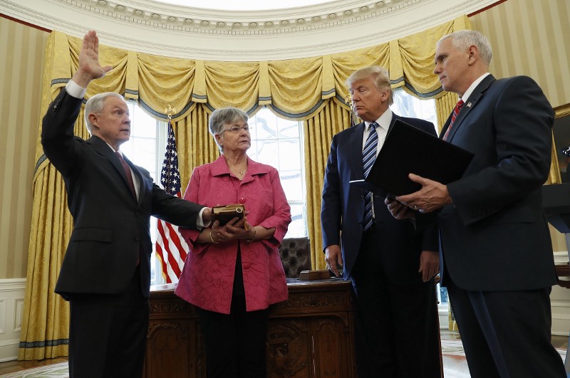 President Donald Trump watches as Vice President Mike Pence administers the oath of office to Attorney General Jeff Sessions, accompanied by his wife Mary, Thursday, Feb. 9, 2017, in the Oval Office of the White House in Washington. CREDIT: AP/Pablo Martinez Monsivais