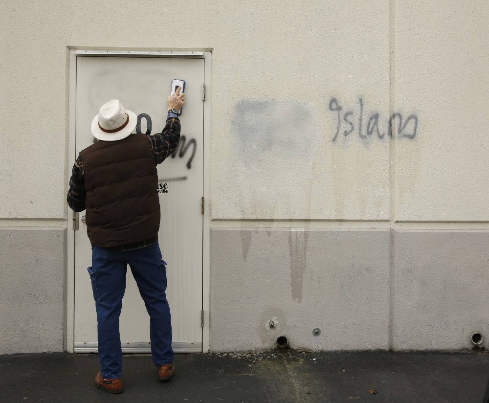 Tom Garing cleans up racist graffiti painted on the side of a mosque in what officials are calling an apparent hate crime in Roseville, California. The Tarbiya Institute was spray-painted with a dozen obscene and racist slurs, including “Muslim out.” CREDIT: AP/Rich Pedroncelli