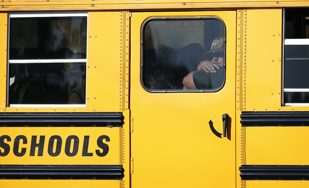 People ride a school bus to collect their belongings and vehicles left behind at Umpqua Community College on Friday, Oct. 2, 2015, in Roseburg, Ore. CREDIT: AP Photo/John Locher