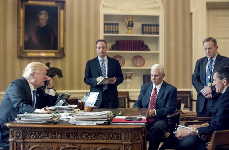 President Donald Trump, accompanied by, from second from left, Chief of Staff Reince Priebus, Vice President Mike Pence, White House press secretary Sean Spicer and National Security Adviser Michael Flynn, speaks on the phone with with Russian President Vladimir Putin, Saturday, Jan. 28, 2017, in the Oval Office at the White House in Washington. CREDIT: AP Photo/Andrew Harnik