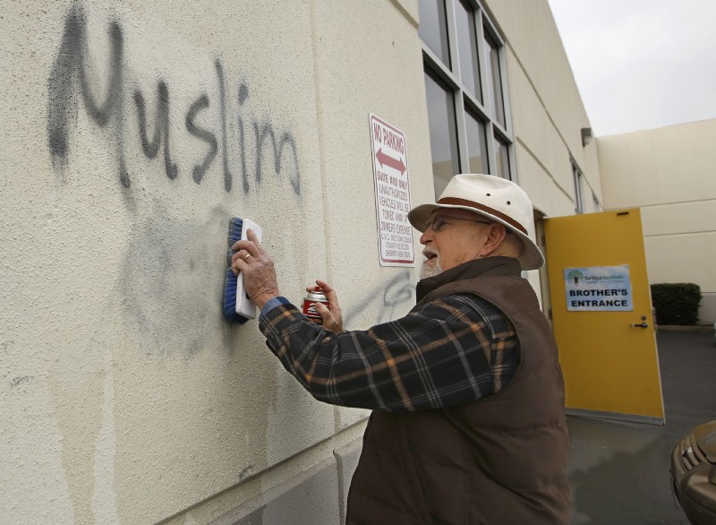 Tom Garing cleans up racist graffiti painted on the side of a mosque in what officials are calling an apparent hate crime, Wednesday, Feb. 1, 2017, in Roseville, Calif. CREDIT: AP Photo/Rich Pedroncelli