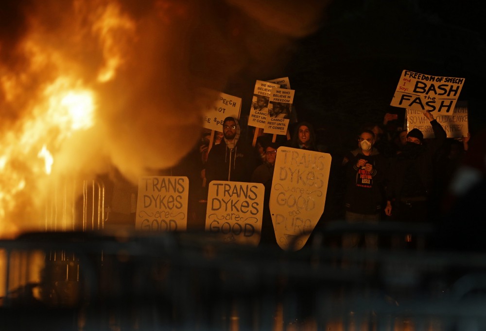 Protestors watch a fire on Sproul Plaza during a rally against the scheduled speaking appearance by Breitbart News editor Milo Yiannopoulos on the University of California at Berkeley campus on Wednesday, Feb. 1, 2017, in Berkeley, Calif. The event was canceled out of safety concerns after protesters hurled smoke bombs, broke windows and started a fire. CREDIT: AP Photo/Ben Margot