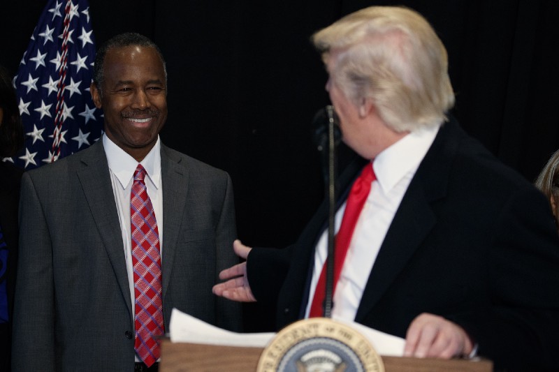 Housing and Urban Development Secretary-designate Dr. Ben Carson, listens as President Donald Trump speaks after touring the National Museum of African American History and Culture. CREDIT: AP Photo/Evan Vucci