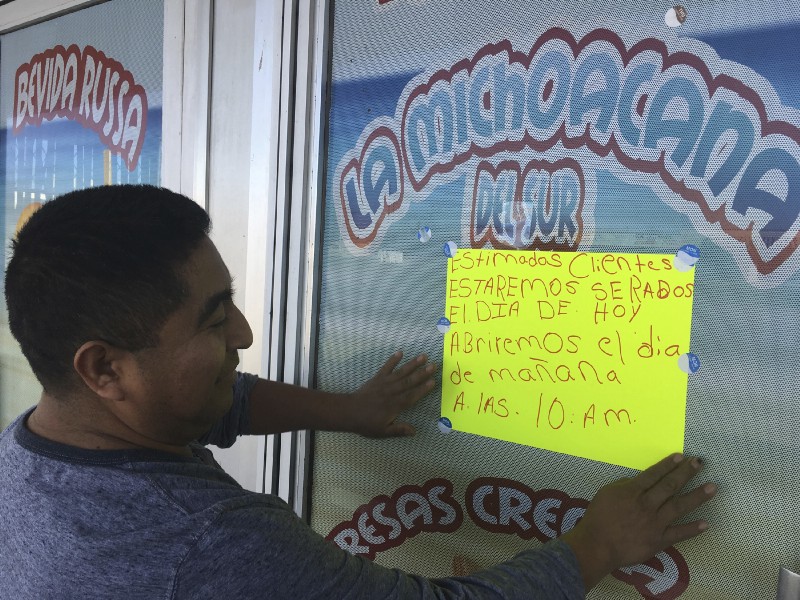 Jose Lopez, owner of La Michoacana Del Sur restaurant in New Mexico, puts up a sign saying it will be closed for the Day Without Immigrants on February 16. CREDIT: AP Photo/Russell Contreras