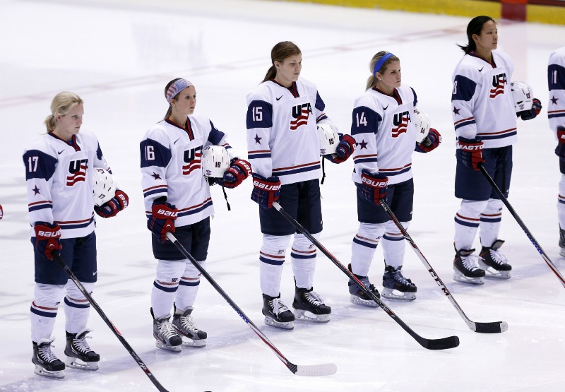 United States players Jocelyne Lamoureux (17), Kelli Stack (16), Anne Schleper (15), Brianna Decker (14) and Julie Chu (13) stand during the national anthems before a Four Nations Cup women’s hockey game against Sweden on Tuesday, Nov. 5, 2013, in Lake Placid, N.Y. CREDIT: AP Photo/Mike Groll