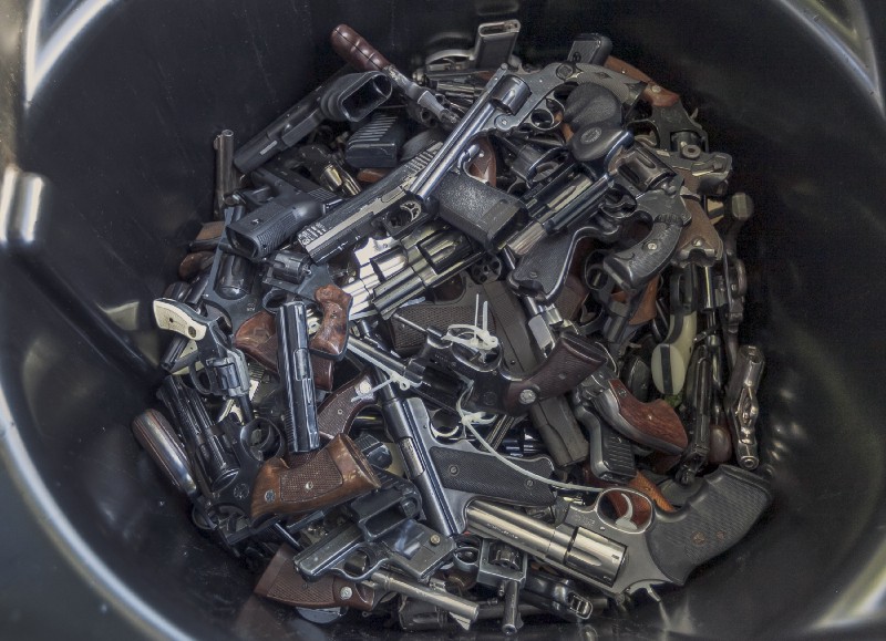 Handguns fill up a trash can for recycling in Los Angeles.CREDIT: AP Photo/Damian Dovarganes