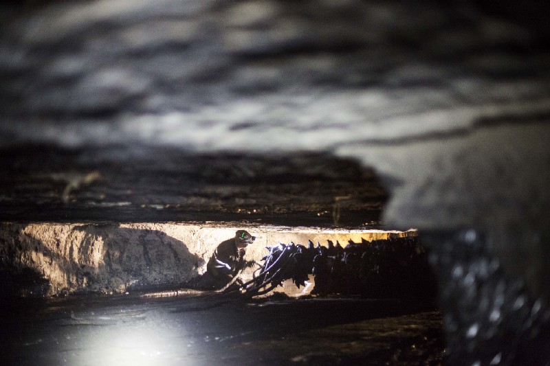 A coal miner works next to a drill in an underground coal mine roughly 40-inches-high, in Welch, W. Va. CREDIT: AP Photo/David Goldman