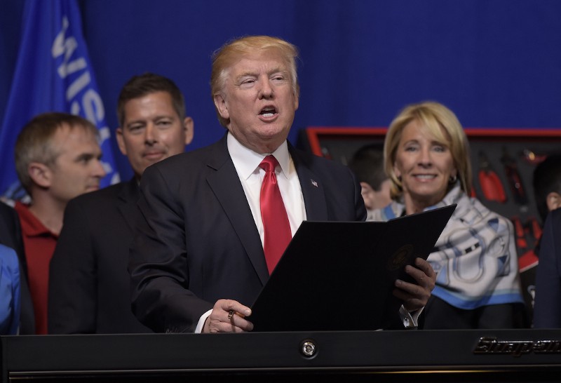 President Donald Trump, flanked by Rep. Sean Duffy (R-WI) and Education Secretary Betsy DeVos, talks in Kenosha, Wis., April 18, 2017. CREDIT: AP/Susan Walsh