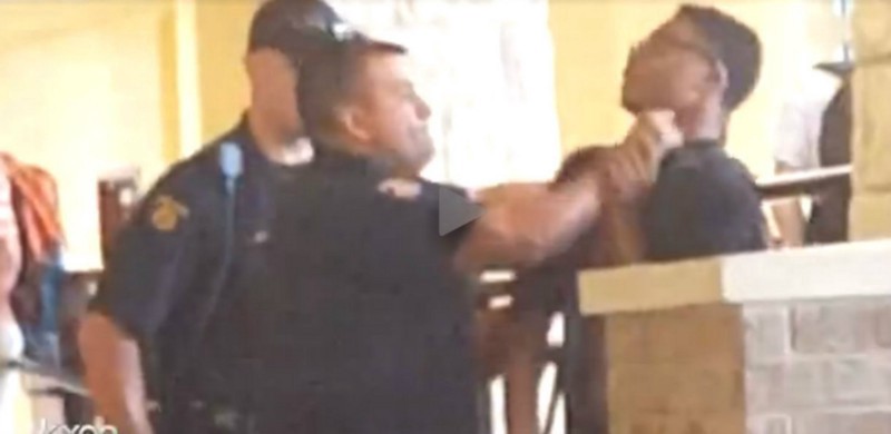 A Round Rock, TX, police officer grabs a 14-year-old student by the throat. CREDIT: KXAN-TV