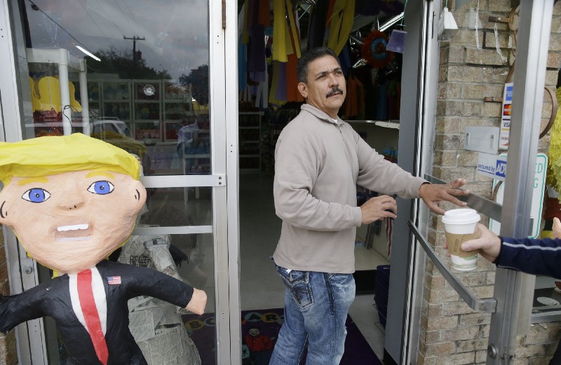 Carlos De La Fuente heads into his party shop to attend to a customer in the Bishop Arts section of Dallas, Wednesday, Nov. 9, 2016. CREDIT: AP Photo/LM Otero