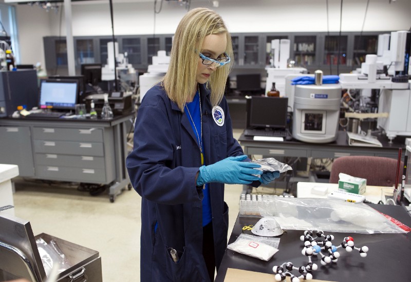 IForensic chemist Emily Dye handles evidence, seized in drug raids, which contains fentanyl analogs at the Drug Enforcement Administration (DEA) Special Testing and Research Laboratory in Sterling, Va. CREDIT: AP Photo/Cliff Owen