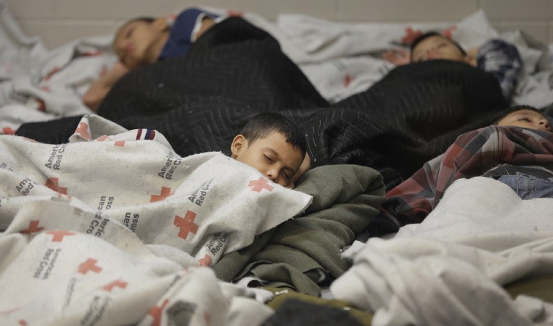 In this Wednesday, June 18, 2014 file photo, detainees sleep in a holding cell at a U.S. Customs and Border Protection processing facility in Brownsville, Texas. CREDIT: AP Photo/Eric Gay, Pool, File