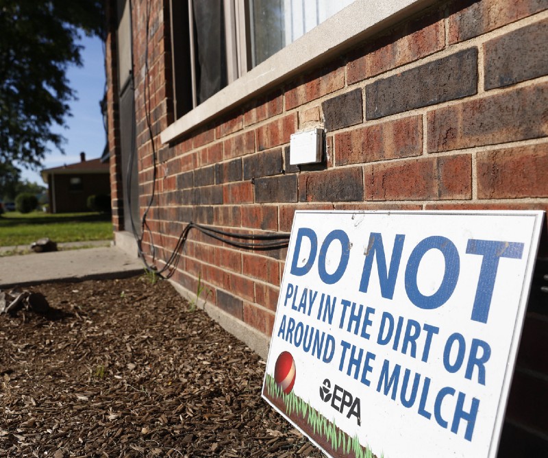 In an Aug. 23, 2016, photo, the EPA warns residents in front of housing complex in East Chicago, Indiana, about soil tainted with industrial contaminants. CREDIT: AP Photo/Tae-Gyun Kim