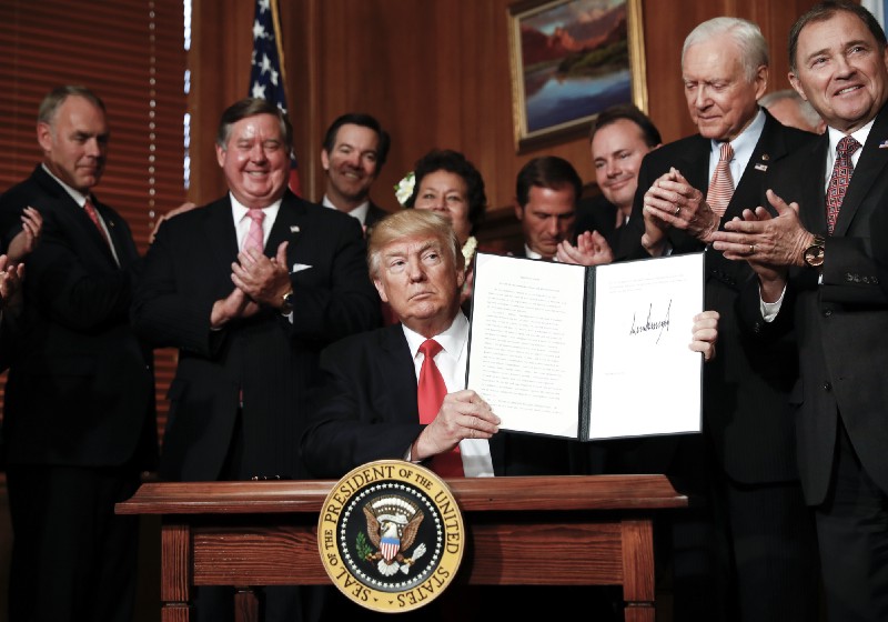 President Donald Trump holds up a signed Executive Order asking for a review of national monument designations at the Interior Department in Washington, D.C. on April 26, 2017. CREDIT: AP Photo/Carolyn Kaster
