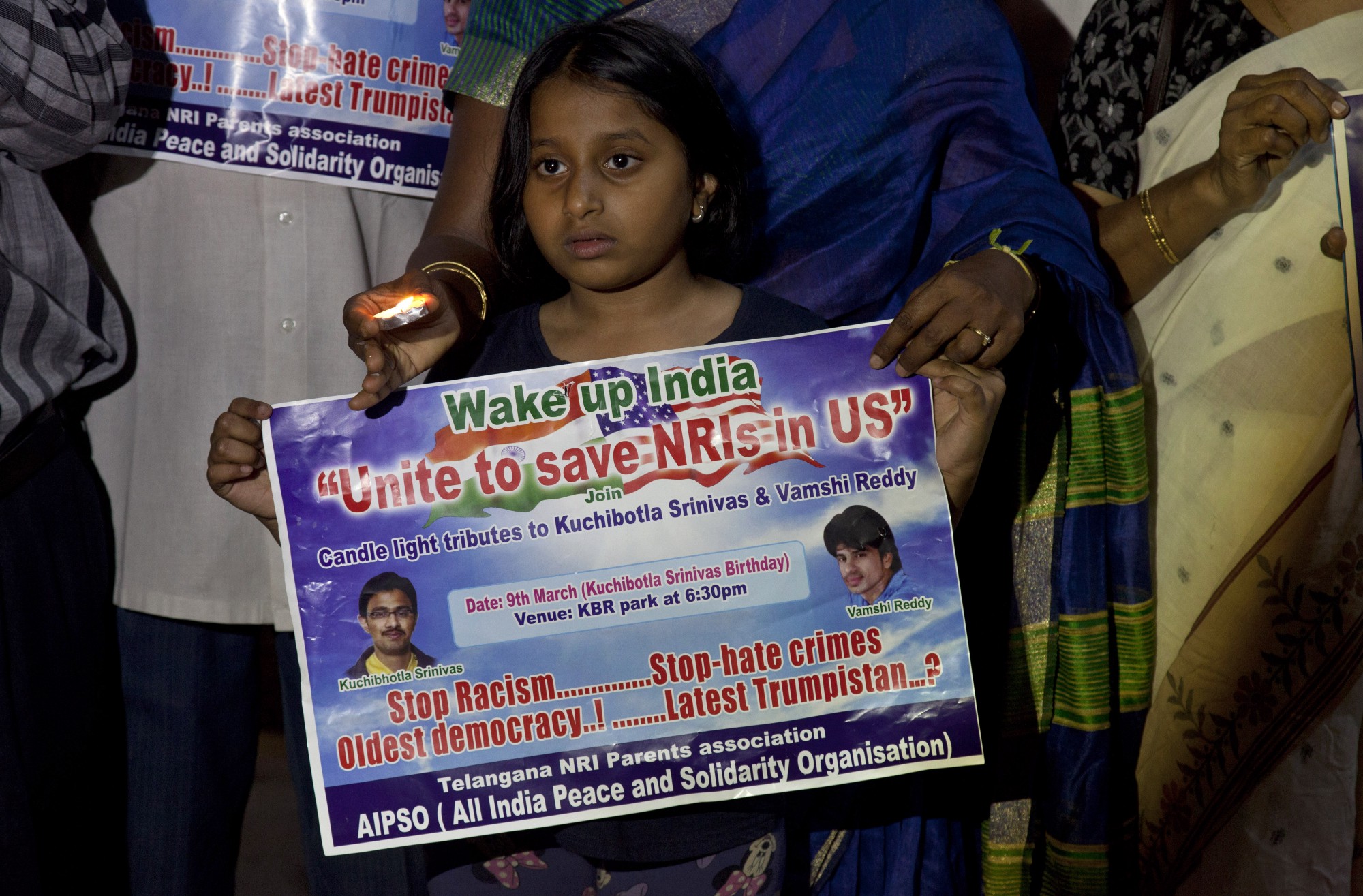 A girl holds a placard as she joins parents of Indians living abroad and others in a candlelight vigil to pay tributes to Srinivas Kuchibhotla in Hyderabad, India. CREDIT: AP Photo/Mahesh Kumar A.