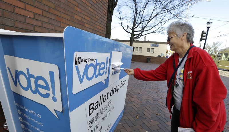 Barb Kearney-Schupp deposits her vote-by-mail ballot in a collection box, Thursday, Nov. 3, 2016, at Seattle Central College in Seattle. CREDIT: AP Photo/Ted S. Warren