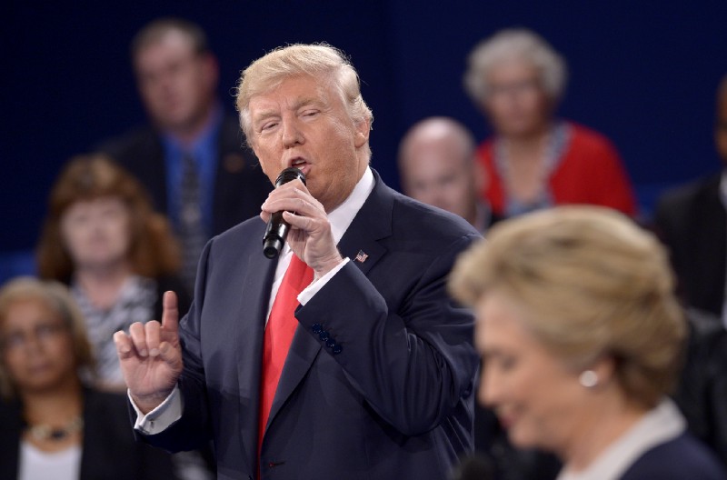 Republican presidential nominee Donald Trump speaks as Democratic presidential nominee Hillary Clinton listen during the second presidential debate at Washington University in St. Louis, Sunday, Oct. 9, 2016. (Saul Loeb/Pool via AP)