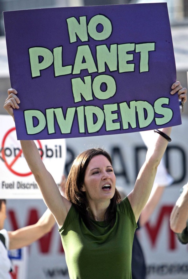 A protester holds a sign outside the Exxon Mobil shareholder meeting in Dallas on May 31, 2006. CREDIT: AP Photo/LM Otero.