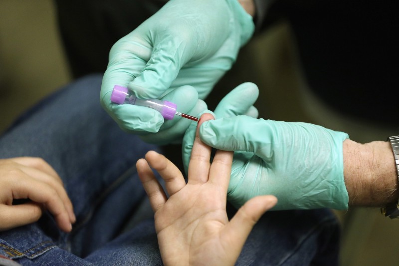 In this Jan. 26, 2016, file photo, registered nurse Brian Jones draws a blood sample from a student at Eisenhower Elementary School in Flint, Mich. (AP Photo/Carlos Osorio, File)
