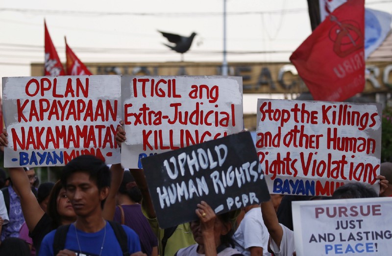 Protesters hold placards during a rally near the Presidential Palace to protest the “extrajudicial killings” under Philippines President Rodrigo Duterte’s war on drugs. CREDIT: AP Photo/Bullit Marquez