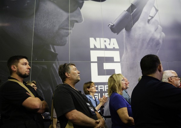 A crowd watches a television from the exhibition hall as President Donald Trump speaks at the National Rifle Association’s annual convention in Atlanta, Friday, April 28, 2017. CREDIT: AP Photo/David Goldman