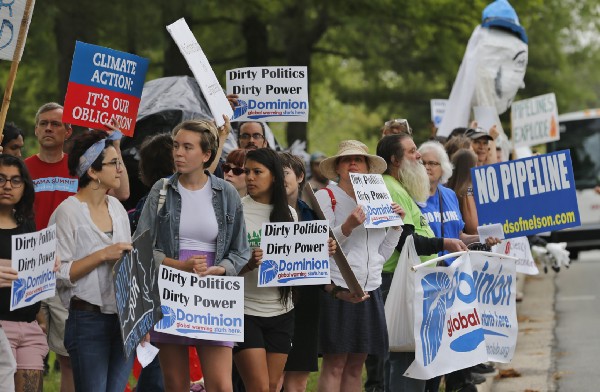 Protesters carry signs near Dominion Energy’s headquarters Richmond, Virginia, opposing the construction of the Atlantic Coast Pipeline. CREDIT: AP Photo/Steve Helber