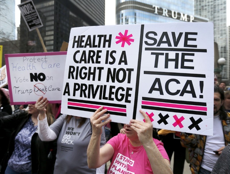 Protesters gather across the Chicago River from Trump Tower to rally against the repeal of the Affordable Care Act Friday, March 24, 2017 CREDIT: Charles Rex Arbogast
