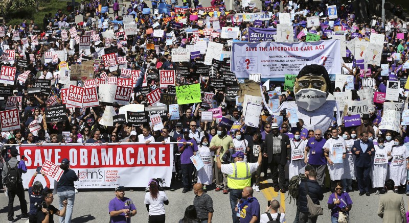 Hundreds of people march through downtown Los Angeles protesting President Donald Trump’s plan to dismantle the Affordable Care Act, his predecessor’s signature health care law, Thursday, March 23, 2017. CREDIT: AP Photo/Reed Saxon