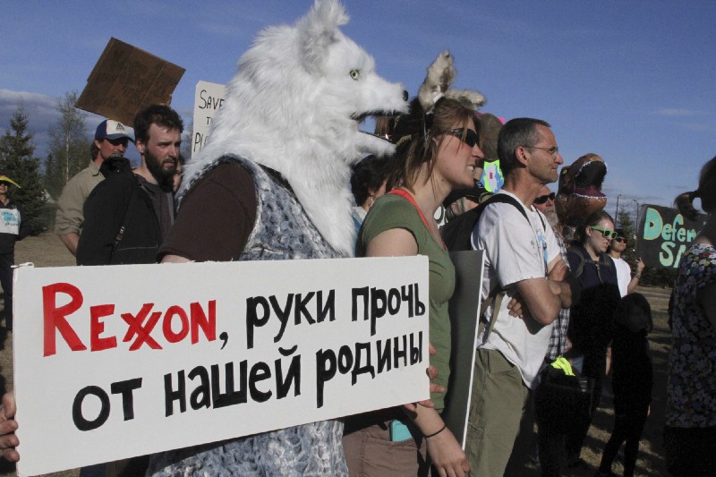 A person in a polar bear costume holds a sign that says “Rexxon, hands off our motherland,” as a group of demonstrators protest U.S. Secretary of State Rex Tillerson at Arctic Council Ministerial. CREDIT: AP Photo/Mark Thiessen