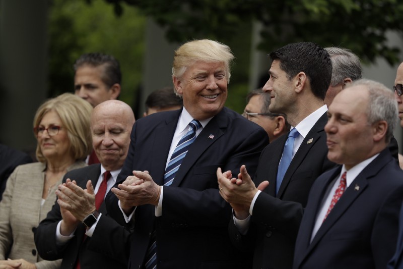 President Donald Trump with Rep. Paul Ryan (R-WI) and Republican House members after they passed the AHCA. CREDIT: AP Photo/Evan Vucci