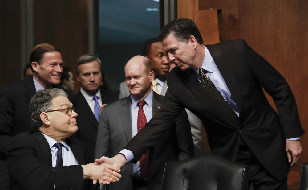 FBI Director James Comey shakes hands with Senate Judiciary Committee member Sen. Al Franken (D-MN) on May 3. CREDIT: AP Photo/Carolyn Kaster
