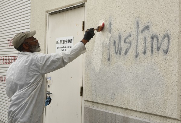 Willie Lawson paints over racist graffiti painted on a Roseville, Ca. mosque in what officials described as an apparent hate crime in February 2017. CREDIT: AP Photo/Rich Pedroncelli