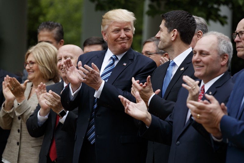 President Donald Trump smiles at Rep. Paul Ryan, R-Wis., after the House pushed through a health care bill, in the Rose Garden of the White House, Thursday, May 4, 2017, in Washington. CREDIT: AP Photo/Evan Vucci
