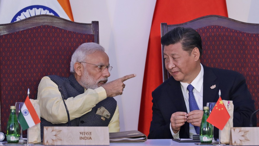 Indian Prime Minister Narendra Modi, left, talks with Chinese President Xi Jinping at the signing ceremony by foreign ministers during the BRICS summit in Goa, India, Sunday, Oct. 16, 2016. CREDIT: AP Photo/Manish Swarup