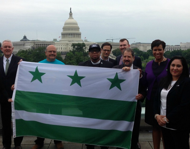 Washington, D.C. Mayor Muriel Bowser (second from right) joins other D.C. officials and activists at the signing of an executive order binding the city to the Paris climate accord. CREDIT: Mark Hand/ThinkProgress