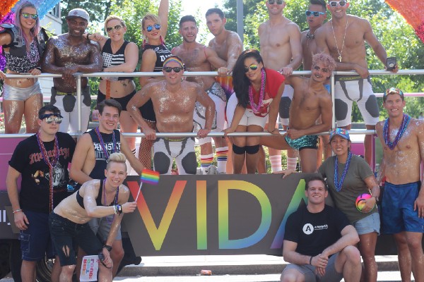 Robinson at the march on Sunday (left) and the VIDA Fitness/Athlete Ally float on Saturday for the Pride Parade. CREDIT: Hudson Taylor, Athlete Ally