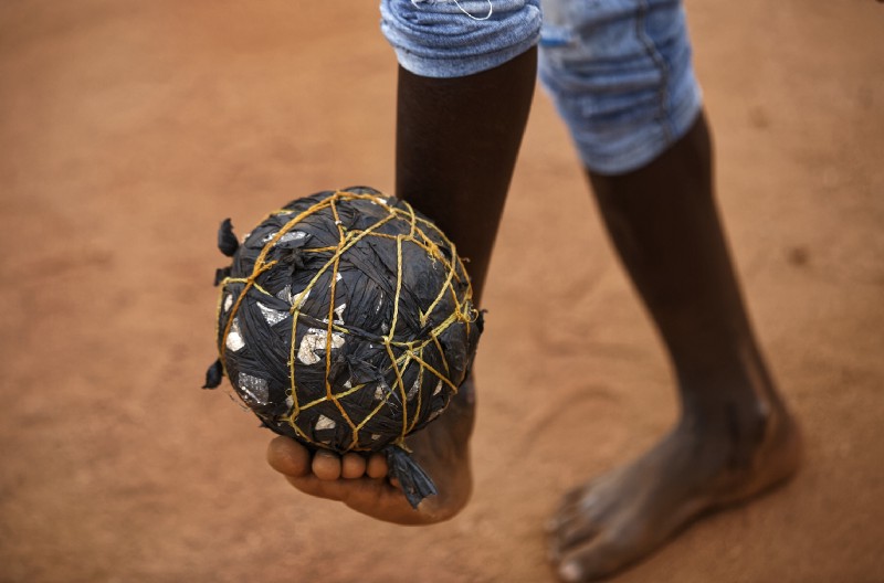 A South Sudanese refugee boy plays with a ball made from plastic bags and string in Bidi Bidi refugee camp in northern Uganda, June 3, 2017. CREDIT: AP Photo/Ben Curtis