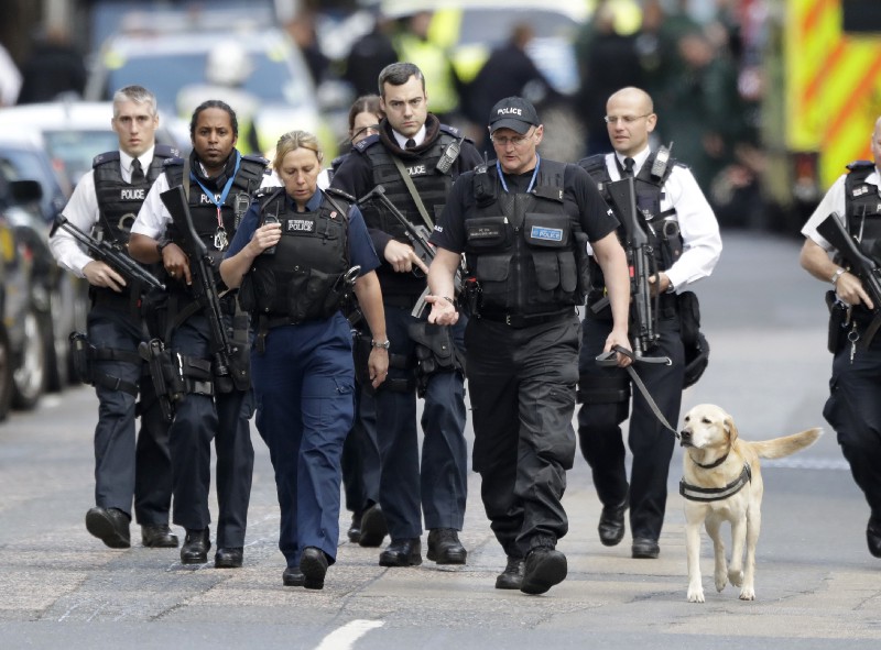 Armed British police officers walk with a detection dog within a cordoned off area after an attack in the London Bridge area of London, Sunday, June 4, 2017. CREDIT: AP Photo/Matt Dunham