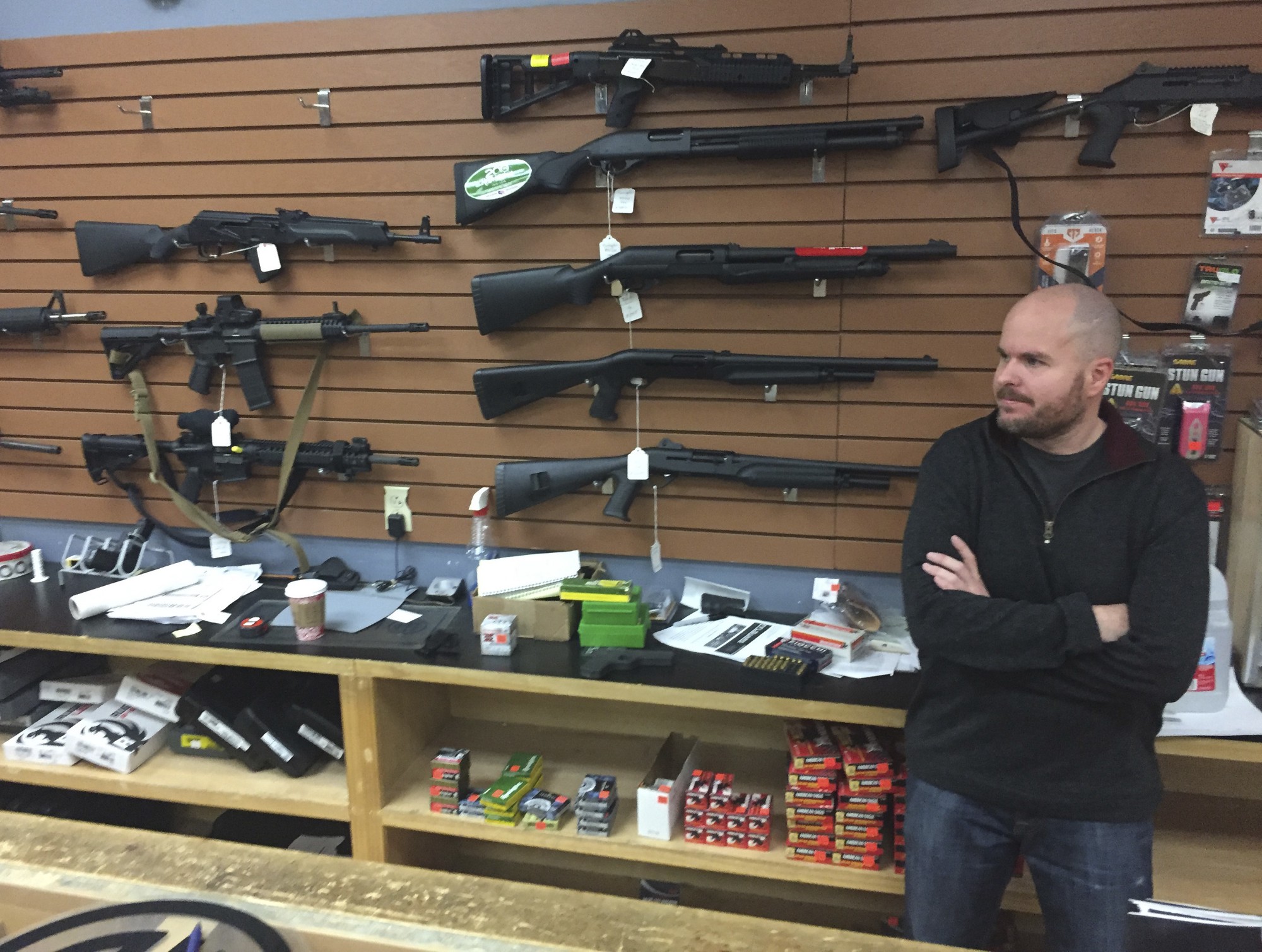 In this Jan. 5, 2017, file photo, Nathan Williams, 37, of Albuquerque, New Mexico, attends to customers at The Outdoorsman gun shop in Santa Fe. Data obtained by ThinkProgress underscores continued problems with the FBI background check system used by federally-licensed firearms dealers in many states. (Morgan Lee/AP)