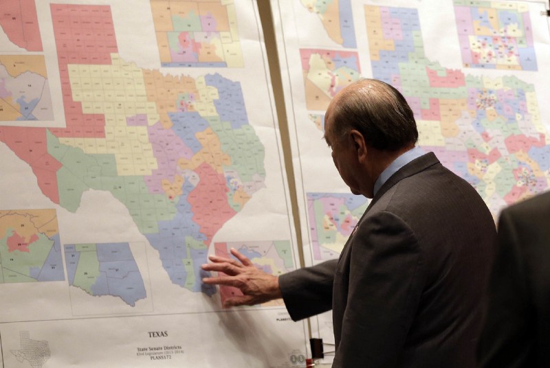 Texas state Sen. Juan “Chuy” Hinojosa looks at maps on display prior to a Senate Redistricting Committee hearing in Austin, Texas, in this May 30, 2013, file photo. CREDIT: Eric Gay/AP