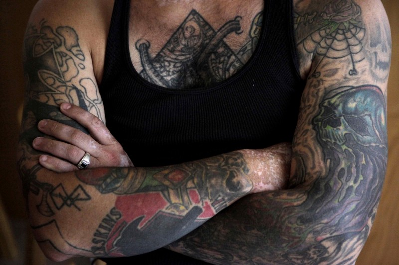 In this Monday, Aug. 1, 2011 photo, former skinhead Bryon Widner folds his arms while resting at his home. Politico reported that the DHS has halted funding for Life After Hate, an anti-white extremism program that helps deradicalize far-right extremists, on Friday. CREDIT: AP Photo/Jae C. Hong