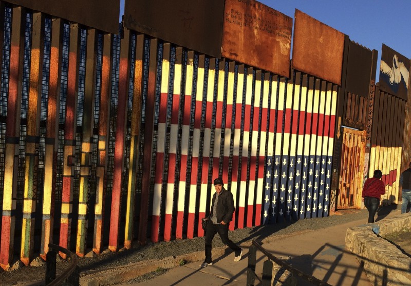 People walk past a mural painted on a border structure in Tijuana, Mexico, on Wednesday, Jan. 25, 2017. CREDIT: AP Photo/Julie Watson