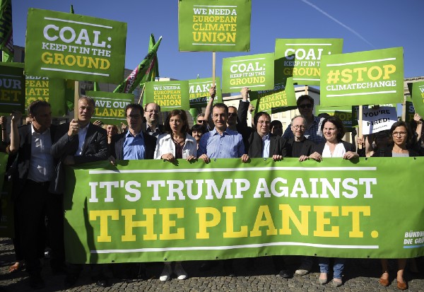 Members of the Green Party in Germany protest President Donald Trump’s decision to exit the Paris climate agreement. CREDIT: Britta Pedersen/dpa via AP