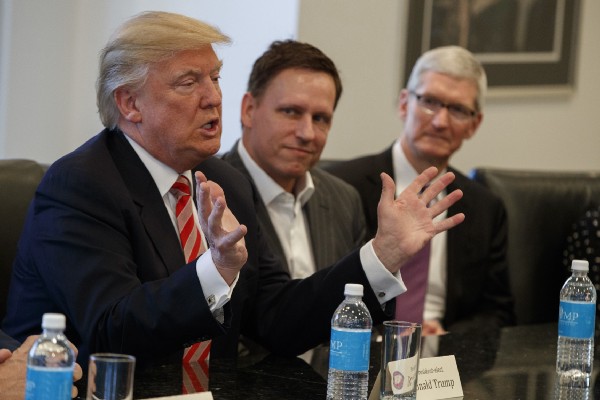 Apple CEO Tim Cook, right, and PayPal founder Peter Thiel, center, listen as President-elect Donald Trump speaks during a meeting with technology industry leaders at Trump Tower in New York, Wednesday, Dec. 14, 2016. CREDIT: AP Photo/Evan Vucci